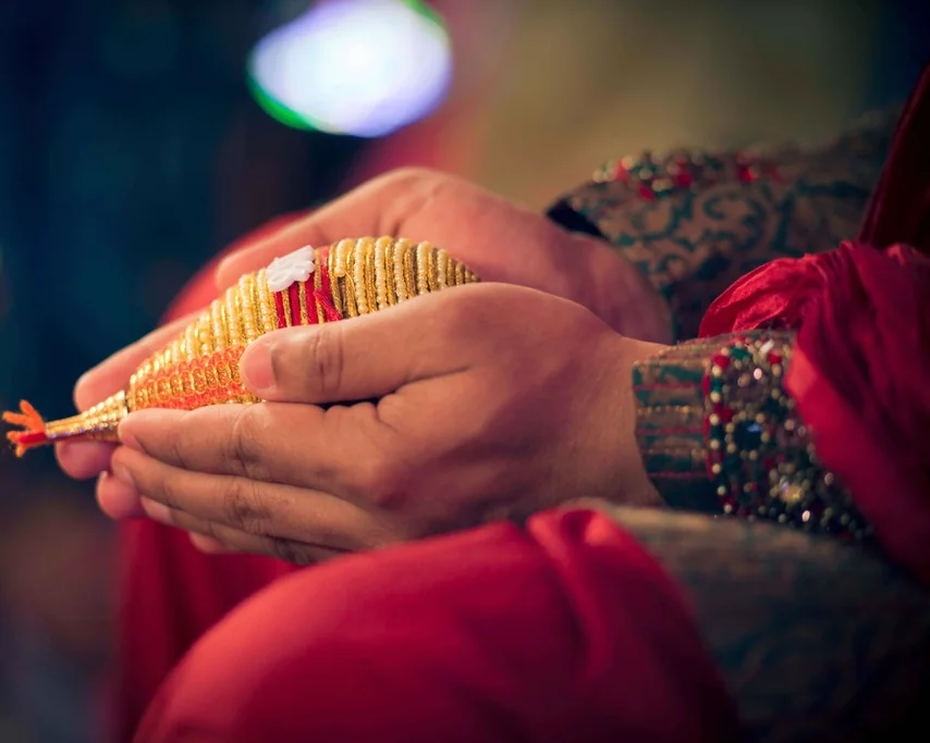 पारंपरिक भारतीय विवाह की एक रस्म में सजा हुआ शंख साथ थामे वर और वधू